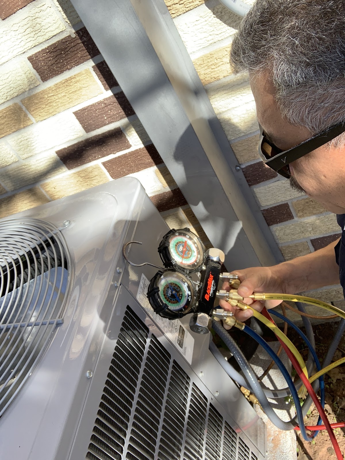 AirPros technician checking refrigerant gauges